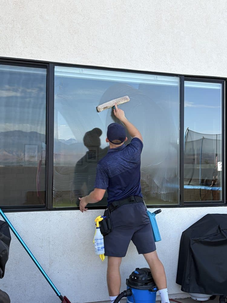 Wave technician squeegeeing a large window